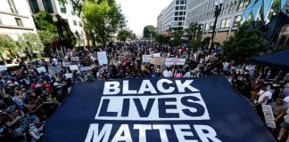 Manifestantes sostienen un cartel gigante en la Plaza Black Lives Matter, cerca de la Casa Blanca, durante una protesta contra la desigualdad racial después de la muerte de George Floyd bajo custodia policial en Mineápolis, en Washington.